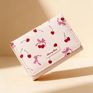 Pink trifold wallet with cherry bow pattern and Cherry Bow logo at 45 degree angle