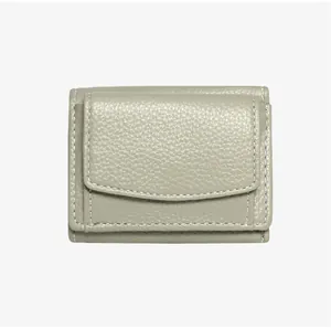 Detailed view of sage green lychee grain leather wallet with white contrast stitching