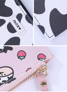 Detail of cow print and strawberry leather wallets with smooth golden metal zippers