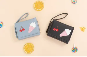 Detail of short PU leather wallets with cute embroidery patterns and wristlet straps