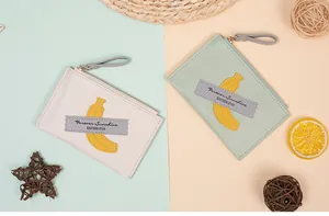 Detailed view of banana print coin purses in cream and mint with secure zip closure