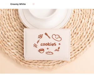 Vue détaillée du portefeuille blanc crème avec broderies de café et de biscuits