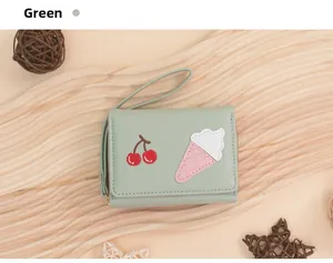 Detail of sage green wallet with cherry and ice cream embroidery and wrist strap