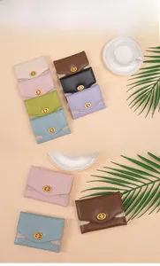 Detail of glitter-trimmed envelope wallets with golden twist-lock closures in multiple colors