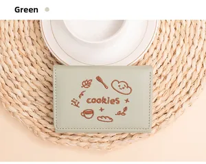 Gros plan d'un portefeuille brodé vert clair avec des motifs de biscuits et de café élégants