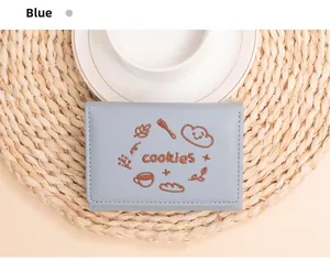 Détail du portefeuille brodé bleu clair avec motif cookies et couture élégante