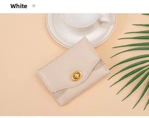 Detail of elegant white tri-fold wallet with gold clasp and champagne glitter accents