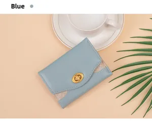Detail of light blue tri-fold wallet with gold rotary clasp and glitter accents