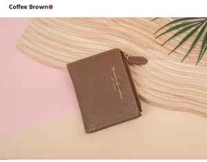 Close-up of coffee brown leather wallet with golden zipper on a decorative wood tray