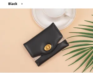 Detail of black tri-fold wallet with gold twist lock and shimmering glitter side panel