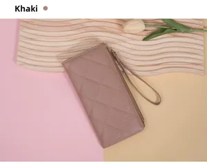 Close-up of khaki quilted leather long wallet with zipper and wristlet strap detail
