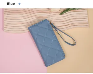 Close-up of blue quilted leather wallet with wrist strap and zipper on stylish background