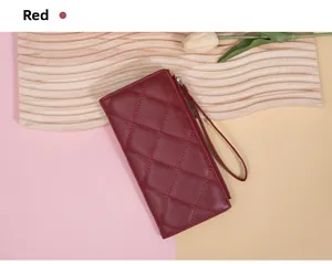 Close-up of red quilted leather long wallet with wristlet on a decorative display