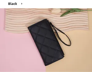 Detail of black quilted long wallet with gold zipper and leather wristlet strap