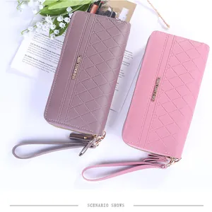 Détail de pochettes en cuir matelassé rose et violet avec des dragonnes amovibles