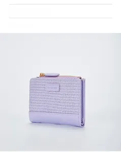 Nahaufnahme der lila Damen-Brieftasche mit Webstruktur, Goldreißverschluss und Etikett
