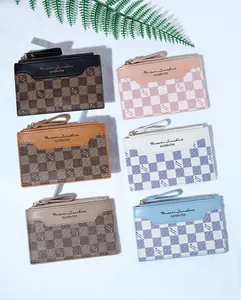 Flat lay of checkered card holders in various colors with zipper closure and leaf detail