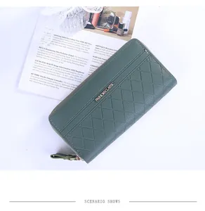 Détail du portefeuille en cuir vert foncé montrant les fentes pour cartes et le cuir