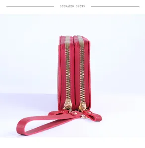 Vue détaillée du portefeuille rouge avec double fermeture éclair et texture grainée de litchi