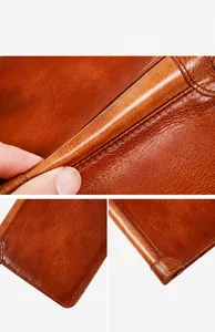 Detailed macro view showing the natural leather grain and fine stitching on the brown wallet