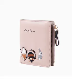 Close-up of a pink embroidered short wallet featuring cute fox and rabbit animal patterns