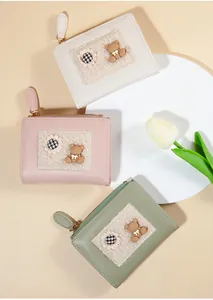 Detailed top view of compact PU leather wallets with cute bear patches and flower accents