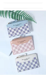 Detailed view of checkered faux leather wallets in blue, pink and white on stands