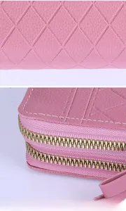 Détail de la pochette rose matelassée pour femme avec double zip et cuir grainé