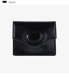 Dettaglio del mini portafoglio nero in pelle lucida con fibbia ovale decorativa