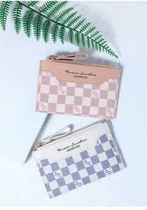 Detail of pink and blue checkered card holders with gold zippers and leather pulls