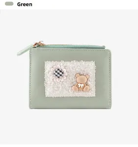 Detail of green cartoon bear wallet featuring sunflower patch and zip closure