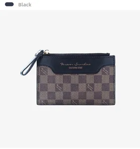 Detail of a black leather zip wallet featuring a brown checkered pattern and gold zipper