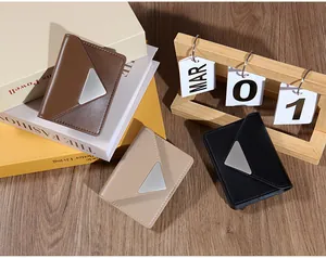 Three minimalist leather card holders in brown, beige, and black with triangle metal plaques