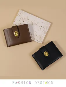 Detail van kleine leren portefeuilles met ovale gouden metalen draaisluiting in bruin zwart