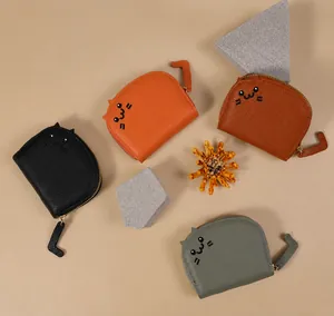 Flache Ansicht von vier Katzen-Minibörsen in Schwarz, Orange, Braun und Grau mit Anhängern
