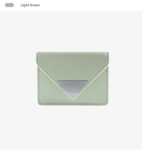 Detail of light green leather card holder featuring a silver triangle metal clasp