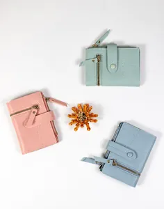 Trois portefeuilles bicolores en similicuir rose, vert et bleu avec détails de couture