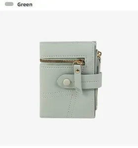 Détail du portefeuille vert clair en similicuir avec fermeture éclair et bouton pression