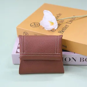 Portafoglio piccolo in pelle marrone con cuciture bianche e chiusura a patta