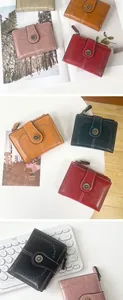 Detail of vintage oil wax leather wallet with daisy buckle and heart perforation