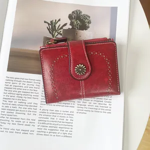 Close-up of vintage red oil wax leather wallet with cutout details and sunflower clasp