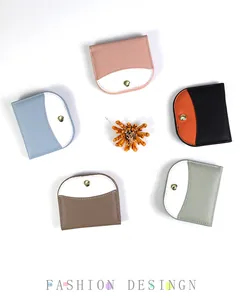 Flat lay of colorful pebble leather slim wallets with metal snap buttons in five shades