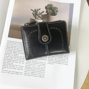 Detail of vintage black faux leather wallet with daisy clasp and white stitching detail