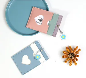 Close-up of pastel PU leather card holder with heart-shaped window and floral pendant