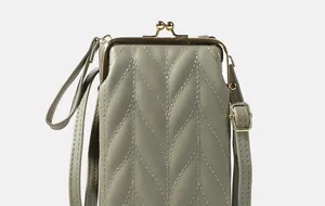 Détail du sac à bandoulière matelassé pour téléphone avec motifs de feuilles et fermoir doré