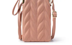 Détail d'un sac bandoulière rose en cuir matelassé avec coutures en V et boucle dorée