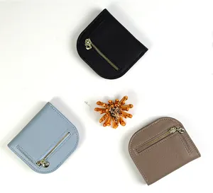 Close-up of pebble leather texture and gold metal ring zippers on small wallets