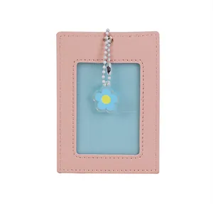 Detail of pink PU leather ID card holder with transparent window and floral charm pendant