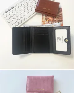Detalle de cartera rosa con grabado de cocodrilo, ranuras para tarjetas y ventana de ID