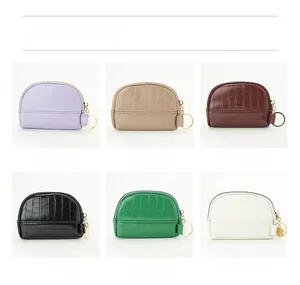 Detail showing various colors of crocodile textured shell coin purses with gold keyrings